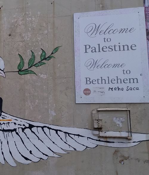 Flügel der Friedenstaube und Schild mit Aufschrift Welcome to Palestine Welcome to Bethlehem